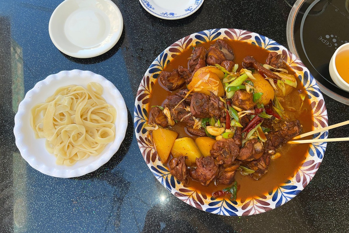 Big plate chicken with potatoes, peppers, glossy sauce, and wide belt noodles.