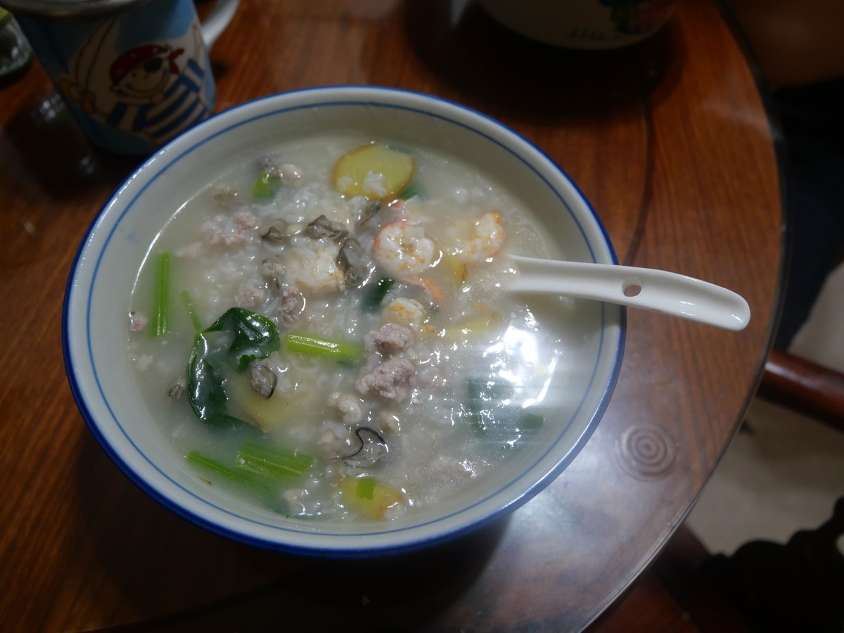 Cantonese fish congee with silky rice porridge, seafood, scallion, and ginger.