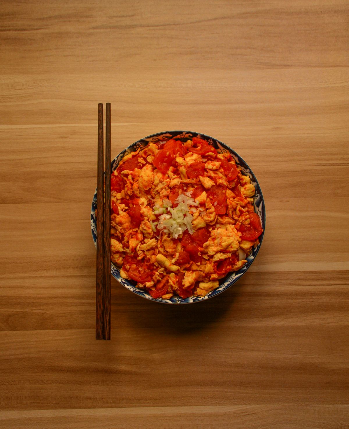 Chinese tomato egg stir-fry with soft egg curds and juicy tomatoes in a bowl.
