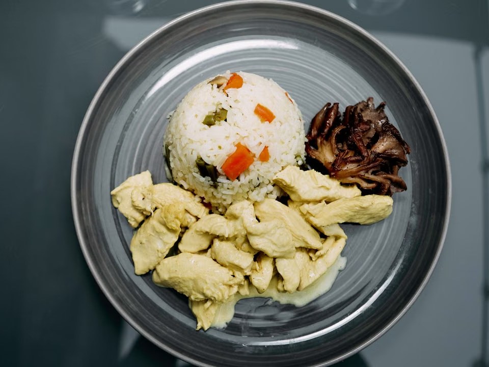 Chicken and mushroom rice served with a mound of vegetable rice.