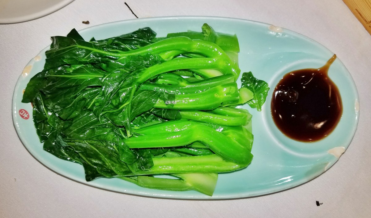 Chinese broccoli gai lan with dark oyster sauce on a plate.