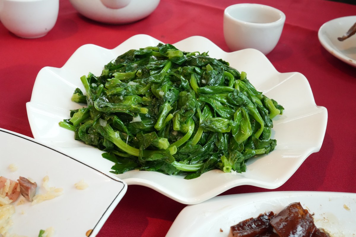 Chinese greens on a white plate with a glossy oyster sauce style finish.