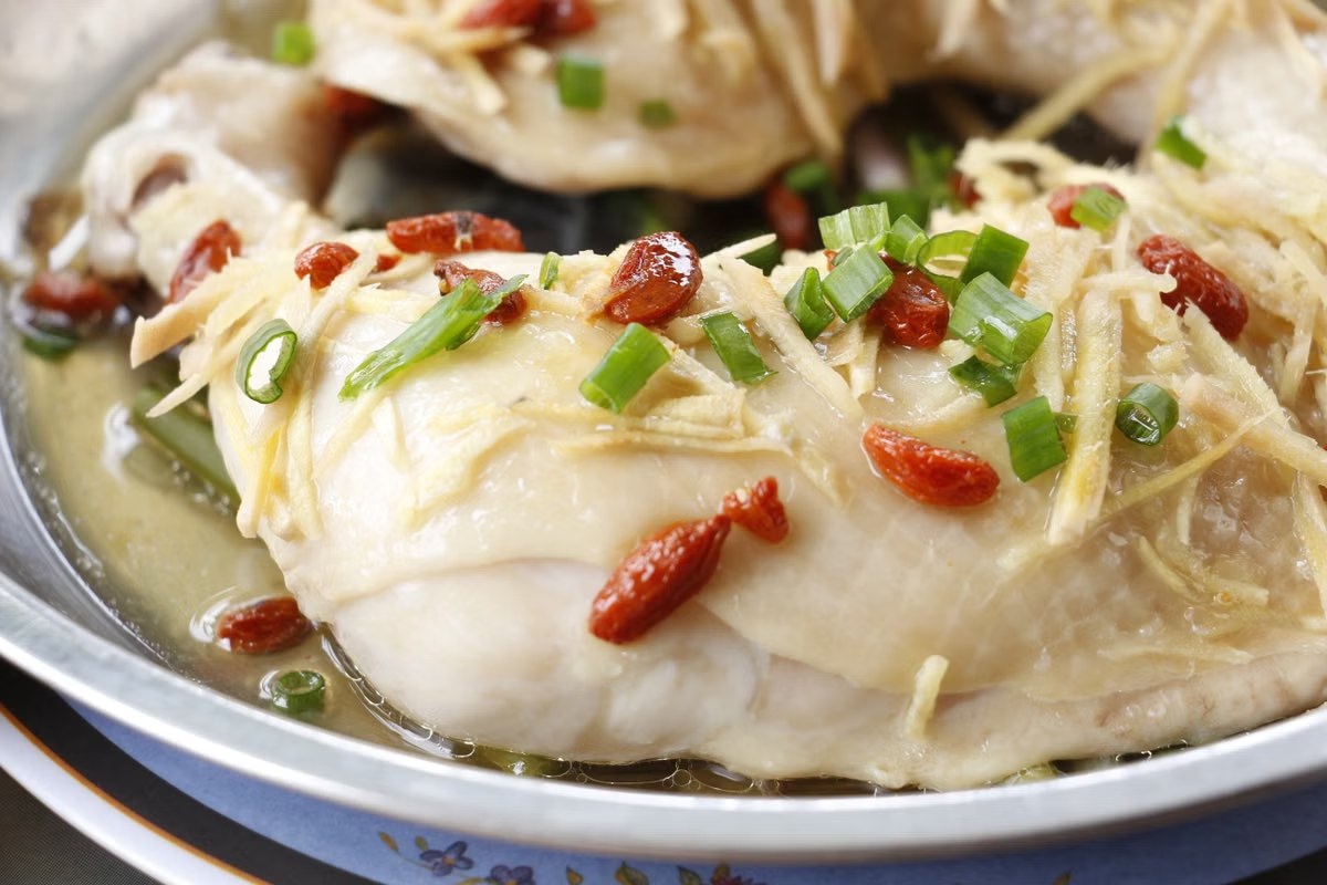 Chinese steamed chicken topped with ginger, scallions, and goji berries.