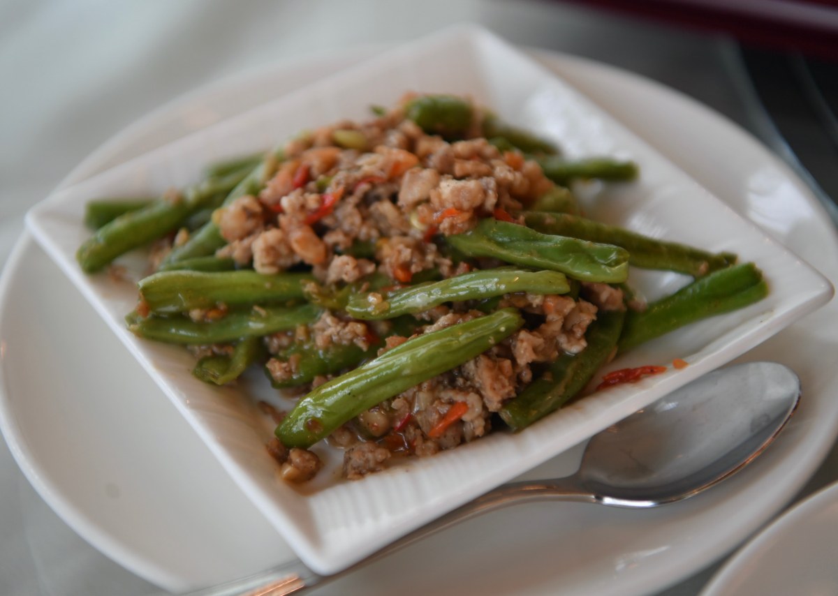 Dry-fried green beans with minced pork and chilies on a white plate.