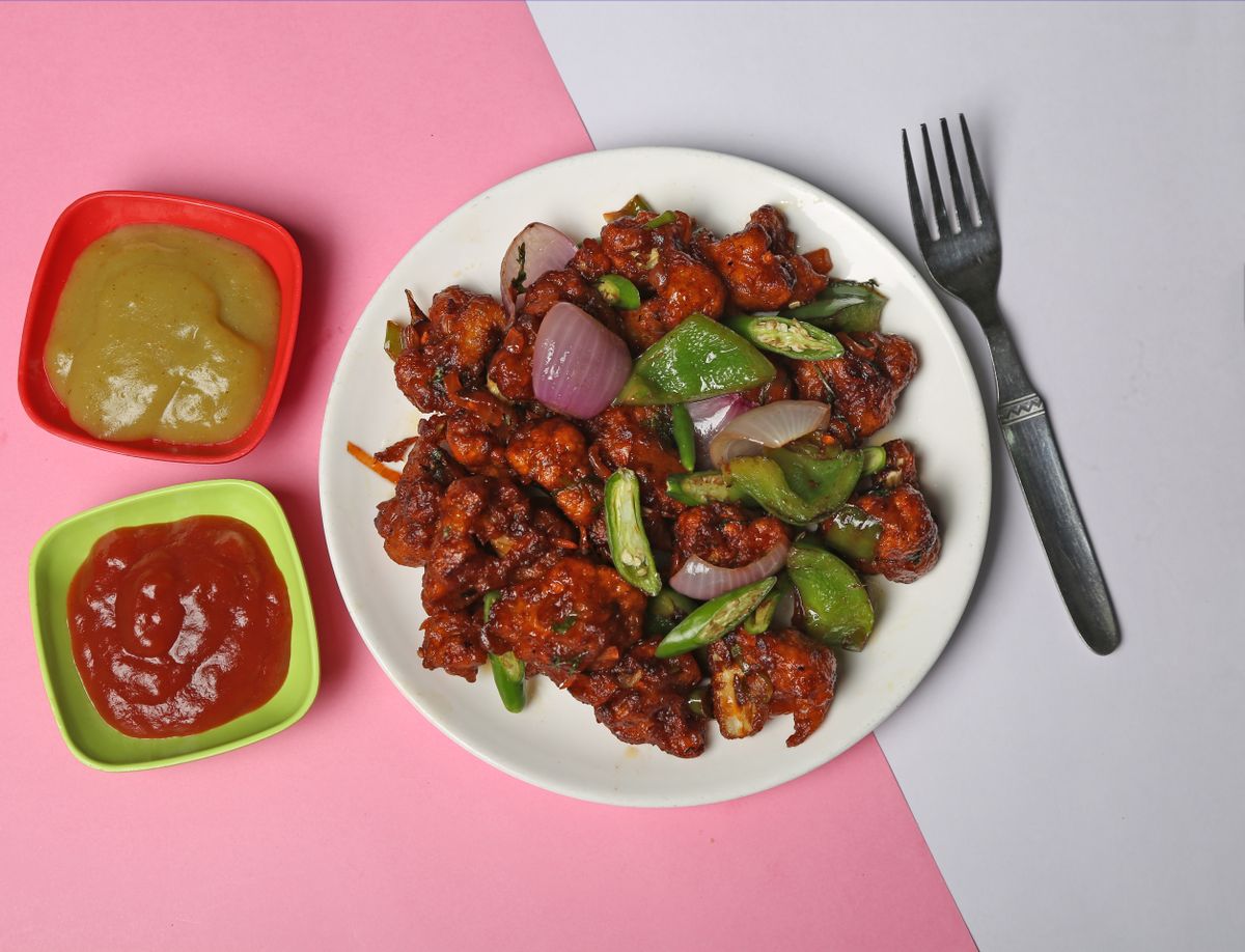 Spicy cauliflower florets with a chili-garlic coating on a plate.