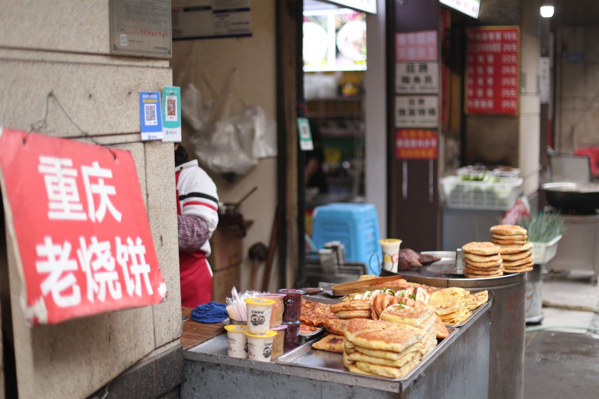 Chongqing street griddle pancakes stacked at a Chinese pancake stall.