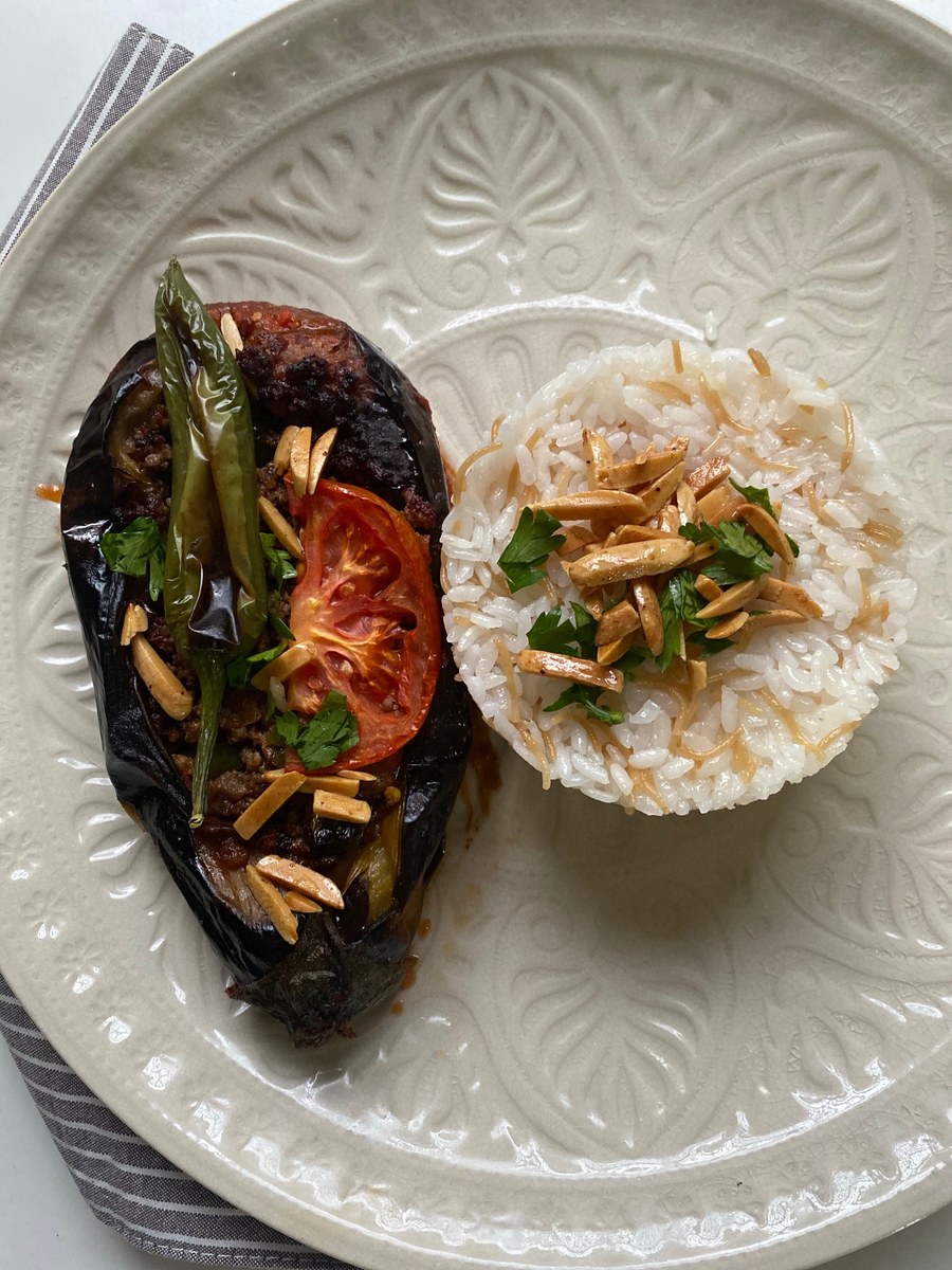 Chinese garlic eggplant with browned aubergine pieces and savory sauce beside rice.