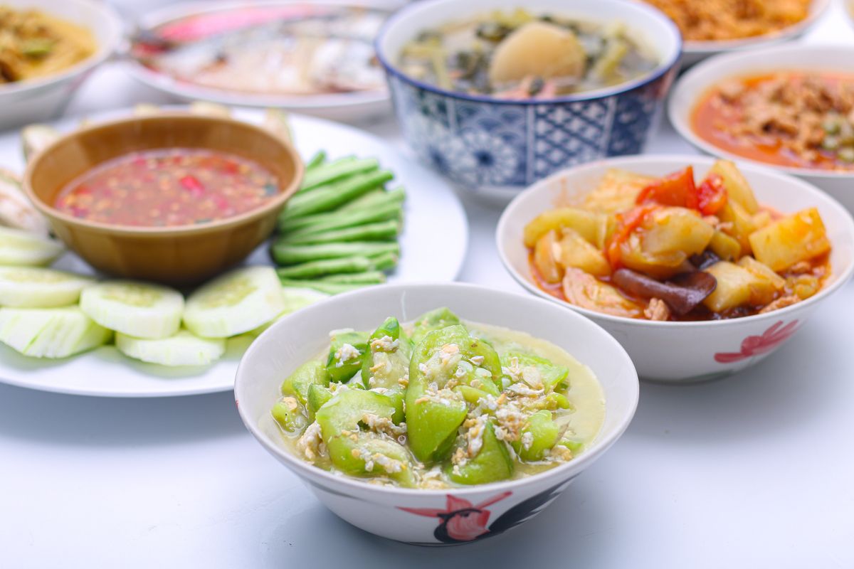 Stir-fried zucchini slices with scrambled egg in a white bowl.