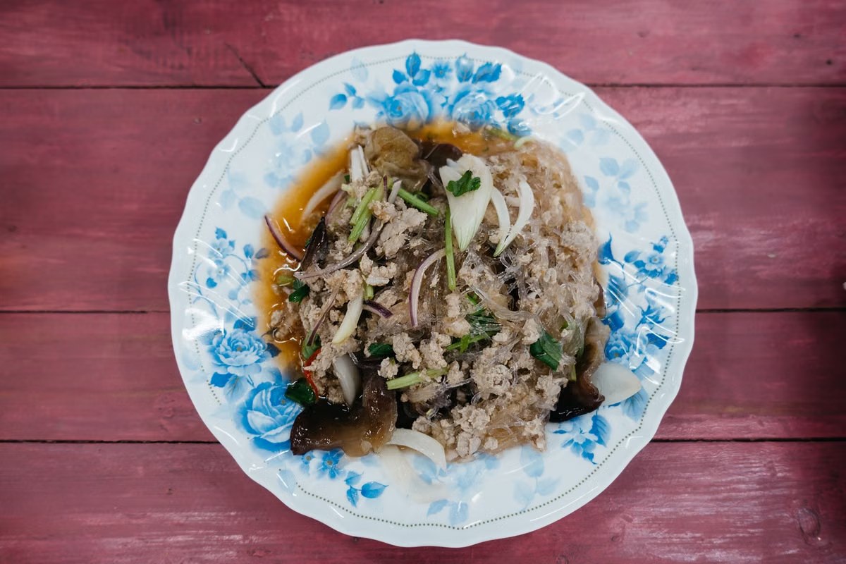 Glass noodles with pork, napa cabbage, wood ear mushrooms, and herbs.