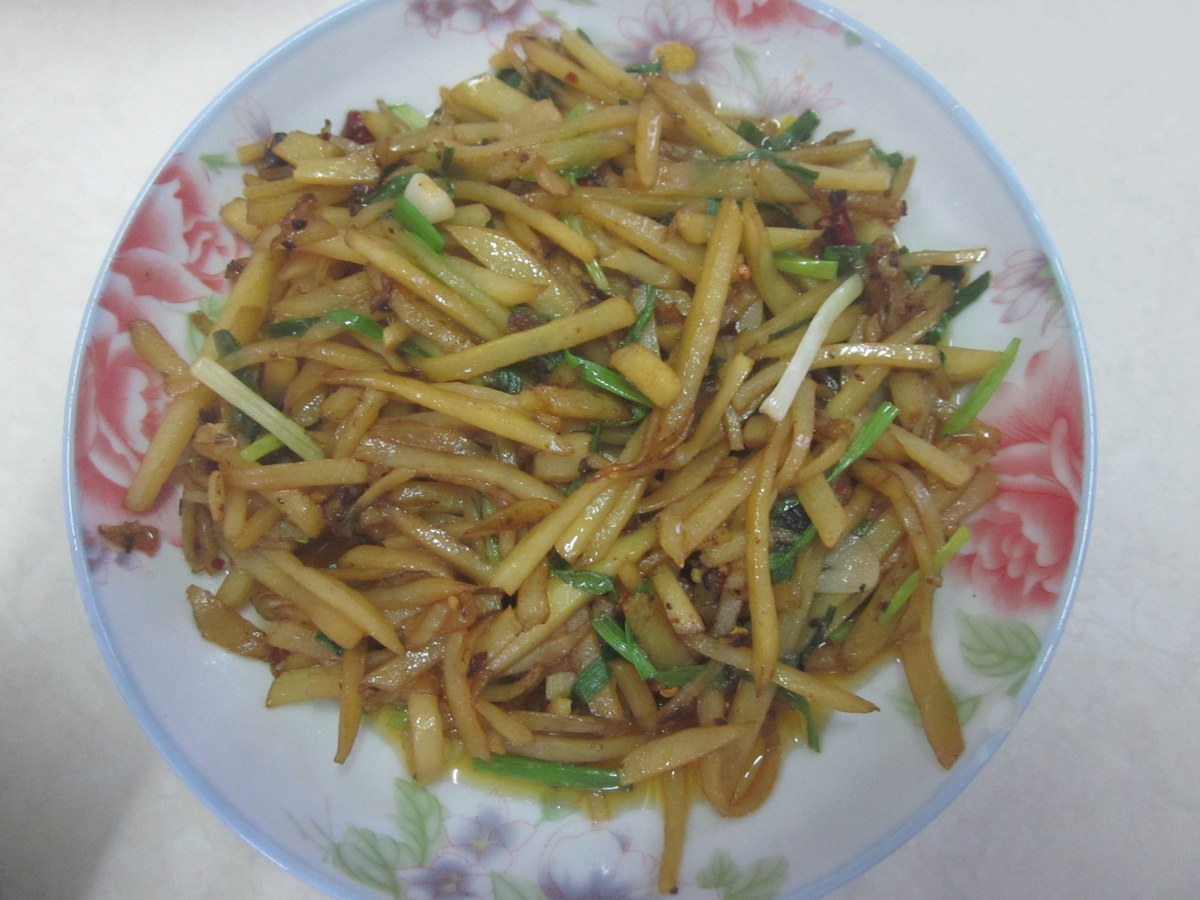Hunan vinegar shredded potato stir fry with thin potato strips on a white plate