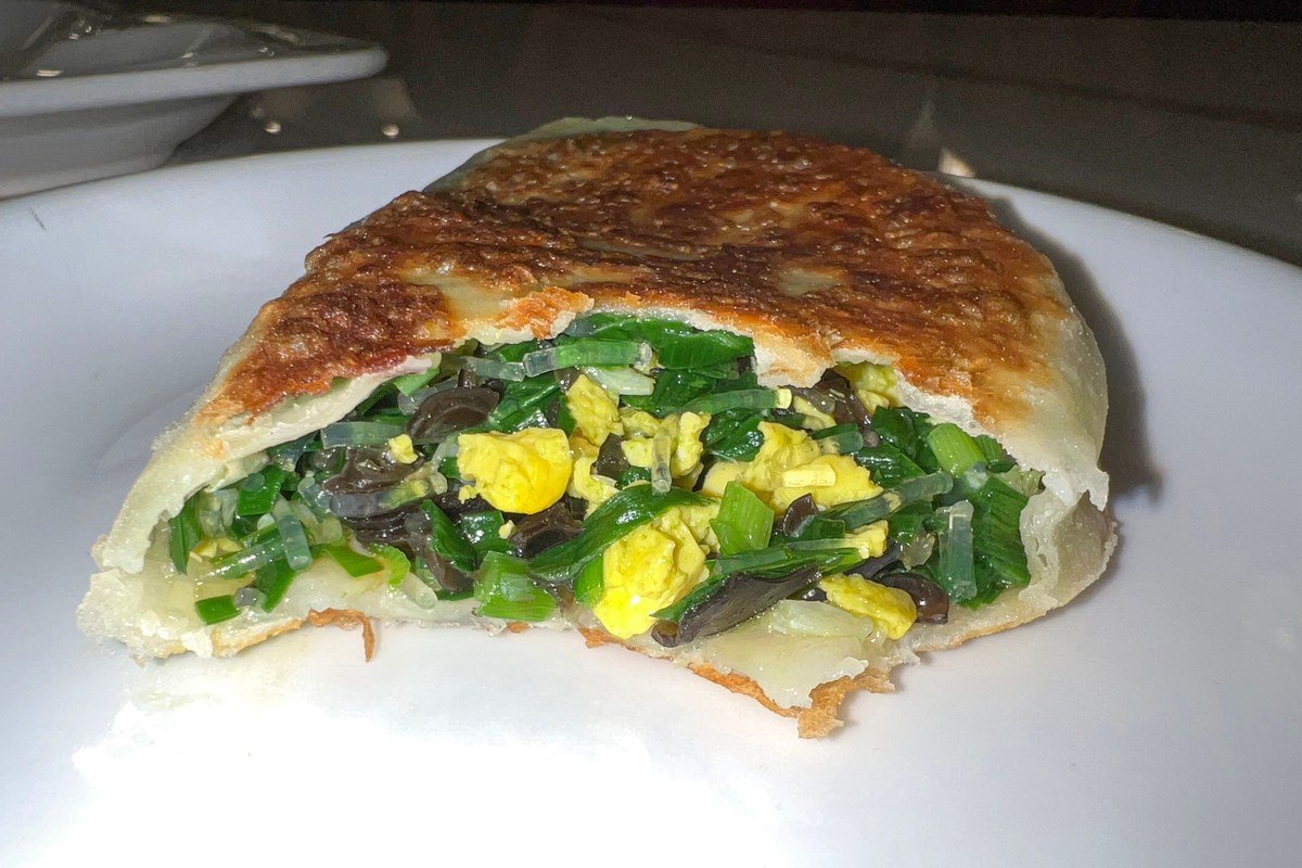 Cut-open jiucai hezi with garlic chives, egg, and a crisp pan-fried wrapper.