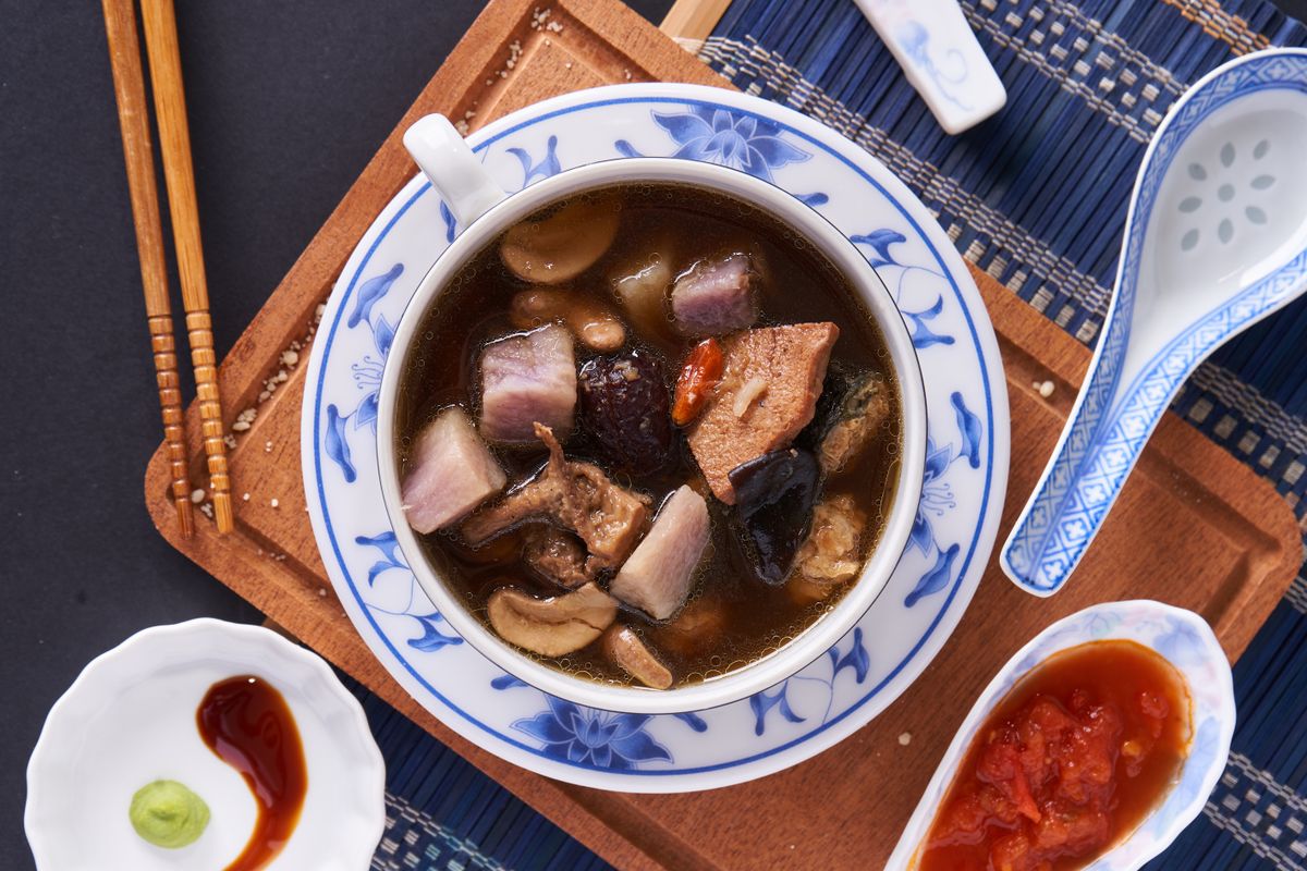 Chinese mushroom tofu soup in a bowl with mushrooms, tofu, and dark savory broth.