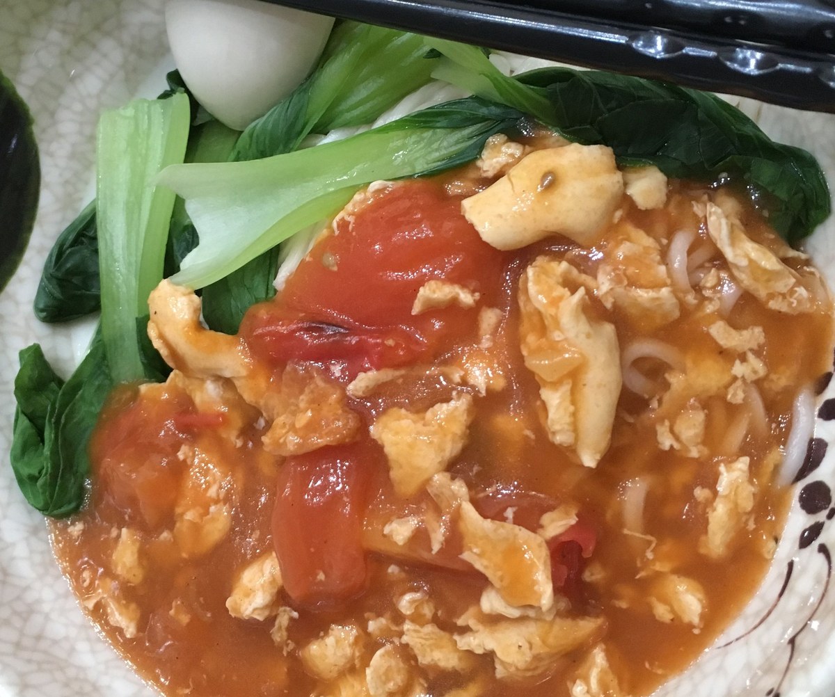 Chinese tomato egg noodles with tomato sauce, soft egg, and wheat noodles.