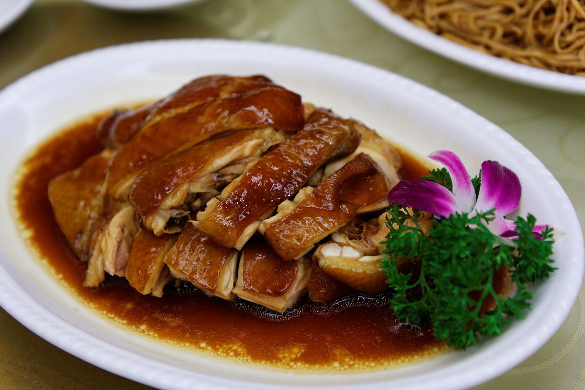 Cantonese soy sauce chicken with glossy brown skin and soy braising sauce.