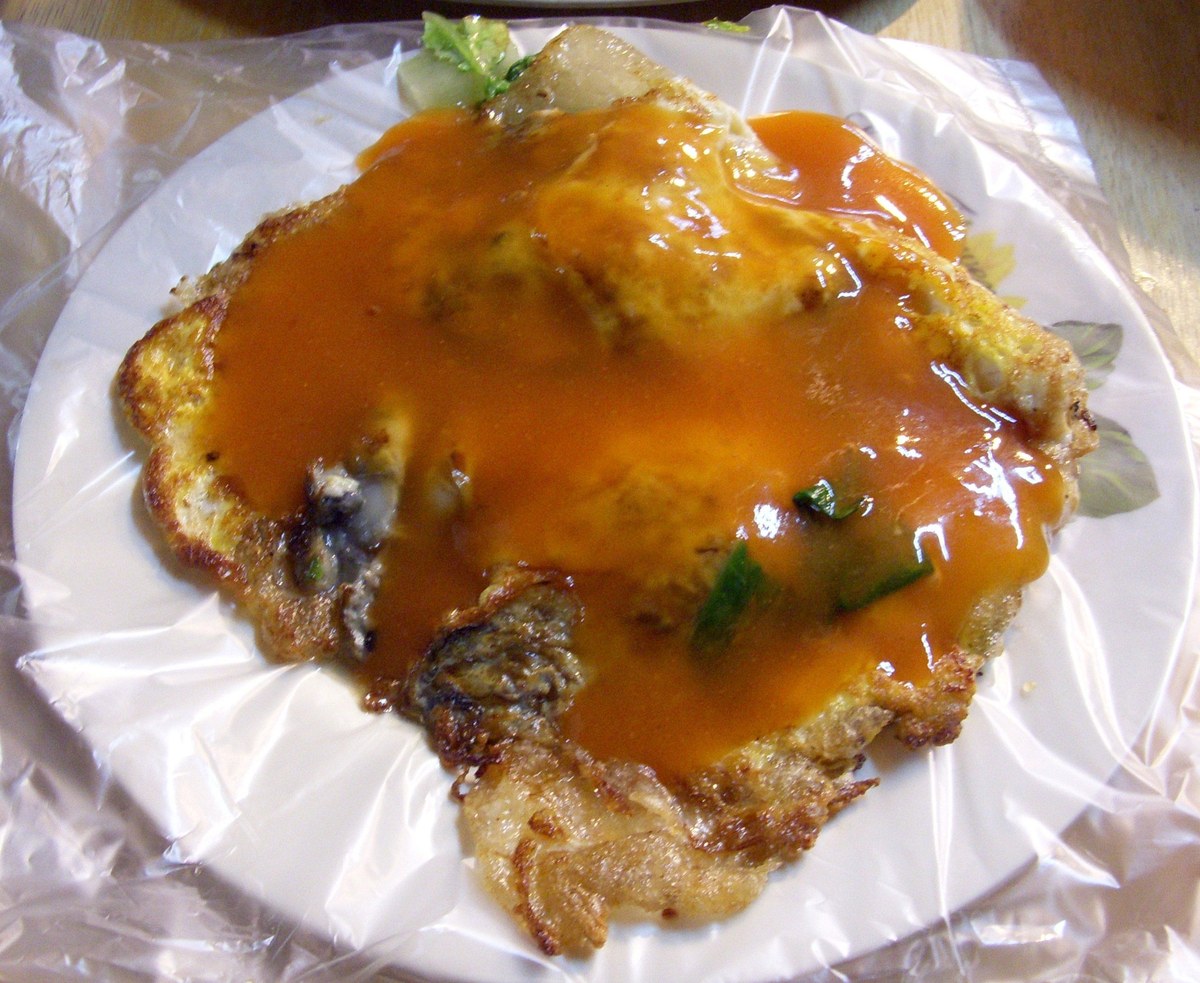 Fujian and Taiwan-style oyster omelet with egg, oysters, starch batter, and orange sauce.
