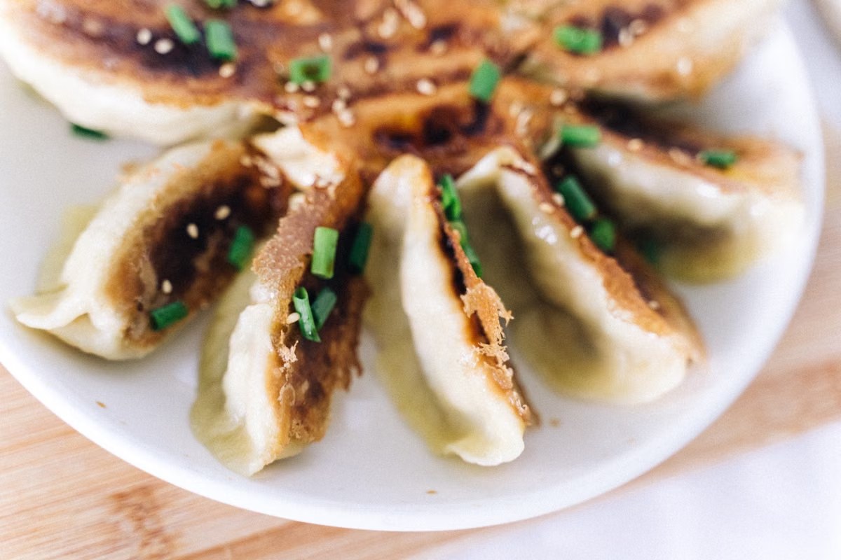 Pan-fried potstickers with browned crisp bottoms and scallions.