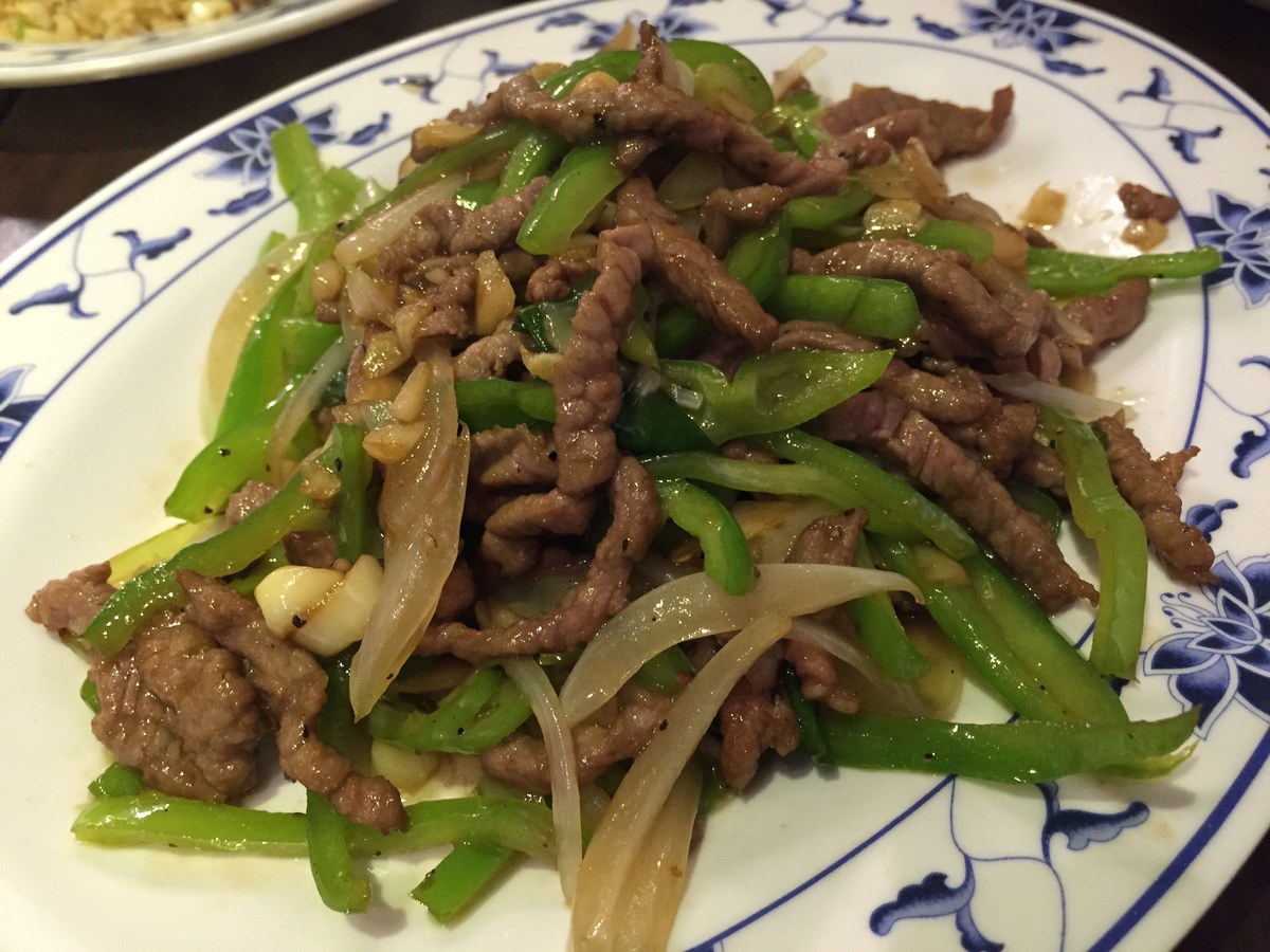 Chinese pepper steak with beef strips and green peppers in a glossy sauce.