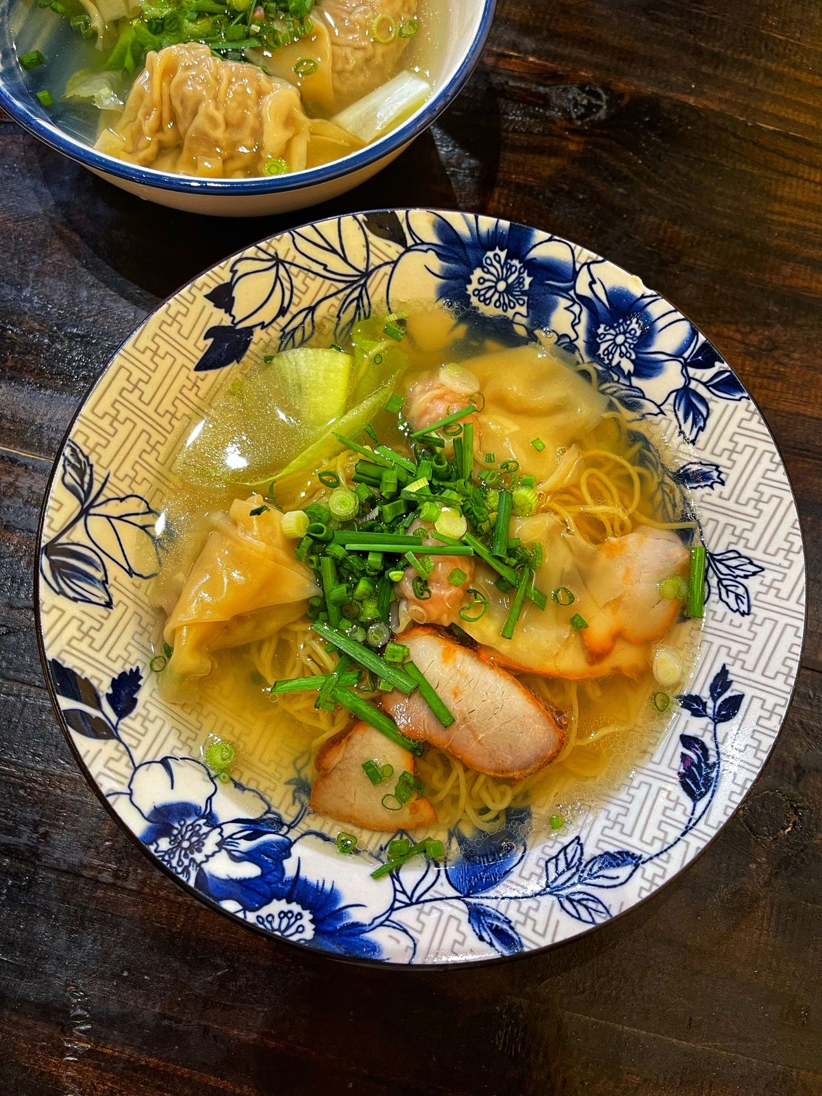 Cantonese wonton noodle soup with egg noodles, wontons, greens, and scallions in clear broth.
