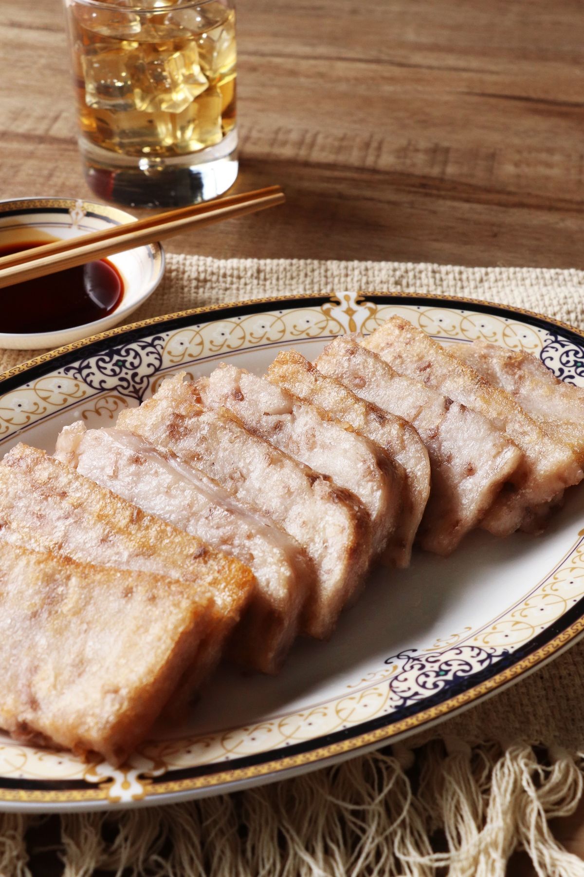 Cantonese crispy pork belly slices on a platter with soy dipping sauce.