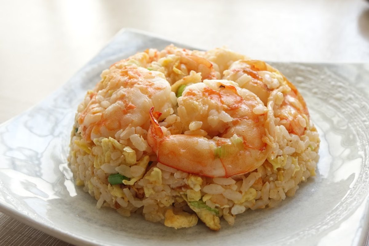 Shrimp fried rice with fluffy egg, scallions, and separate grains.