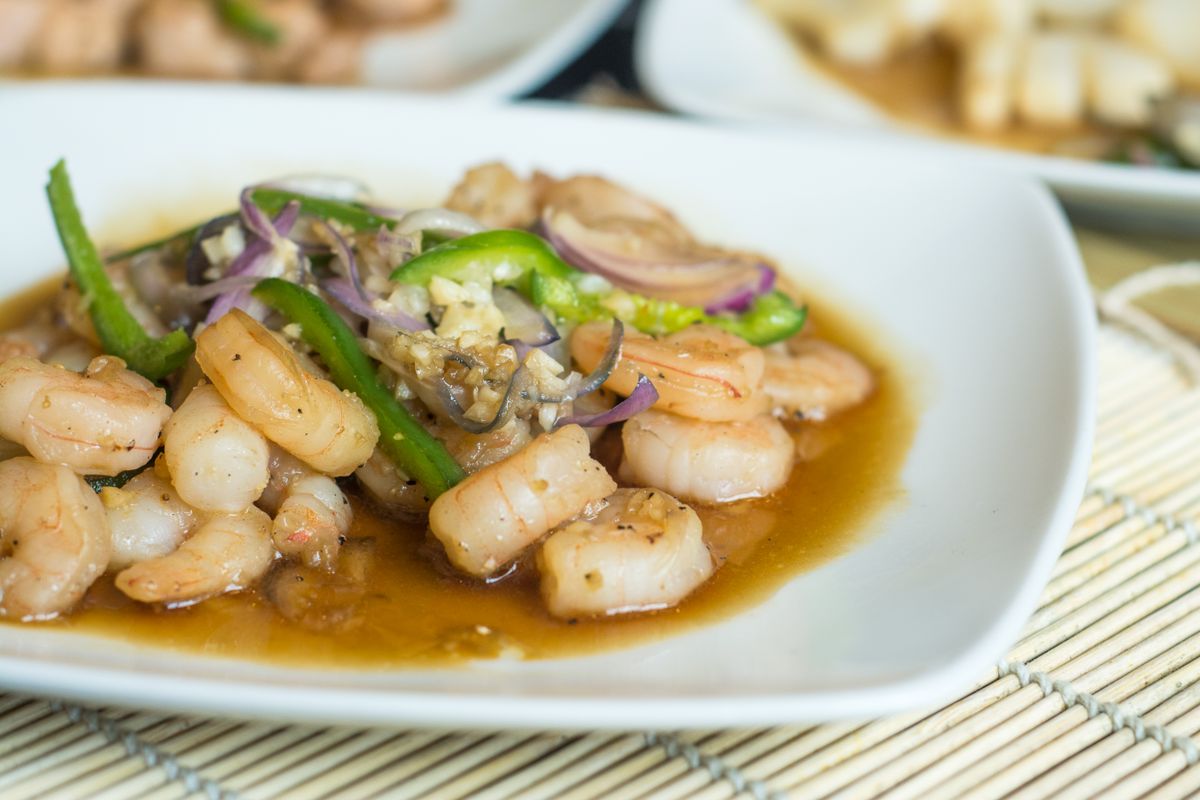 Black pepper shrimp stir-fry with green peppers, red onion, garlic, and glossy sauce.