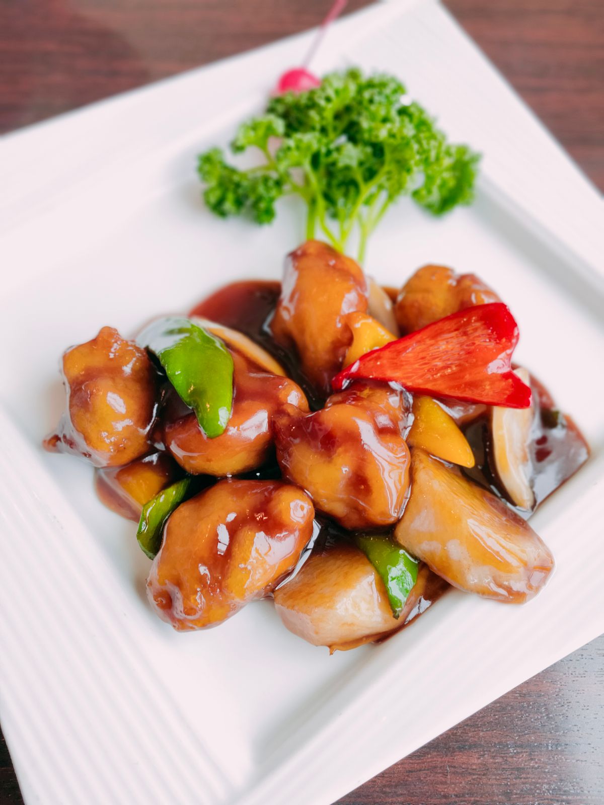 Spicy bamboo shoot and pork stir-fry with glossy pale bamboo shoot pieces, pork, red and green peppers, and dark sauce.