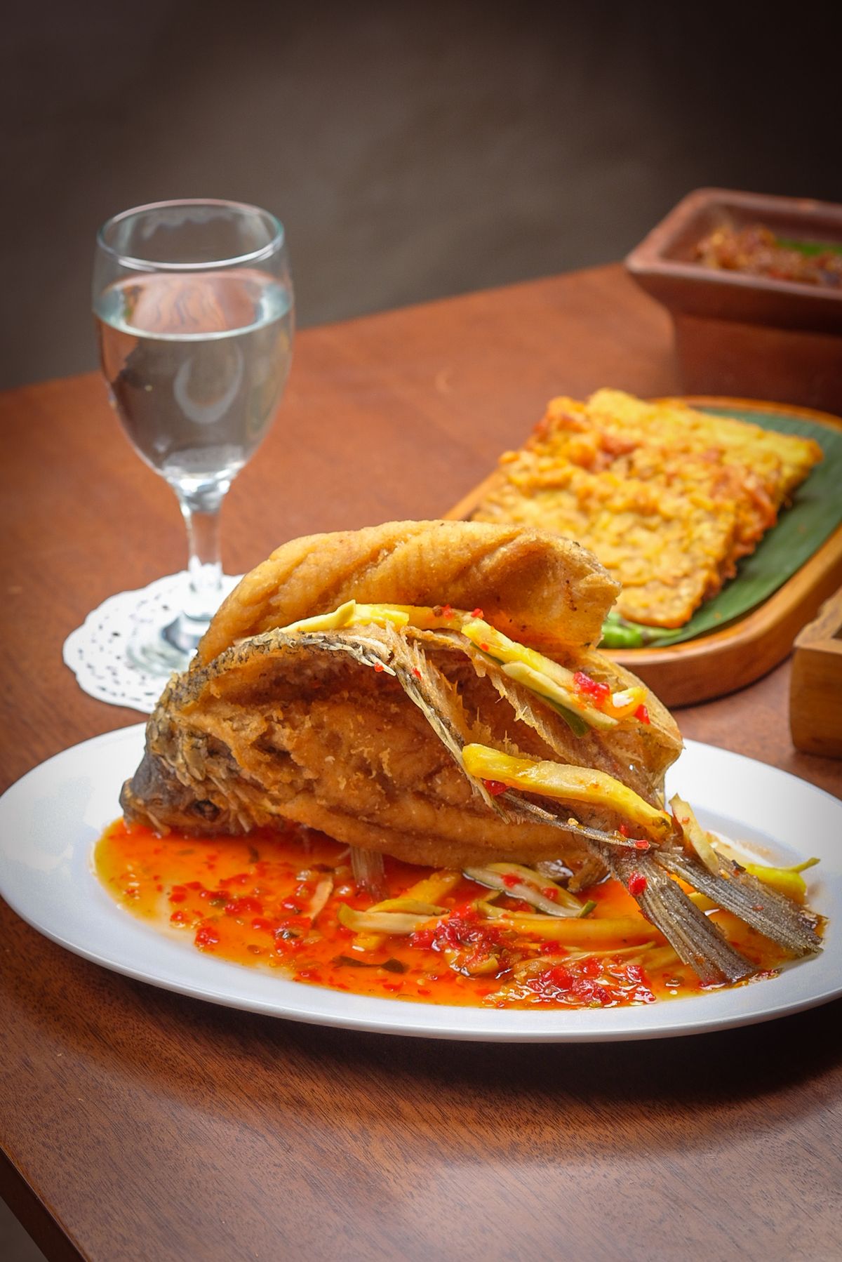 Crispy whole fried fish with red sweet-sour chile sauce and ginger strips.