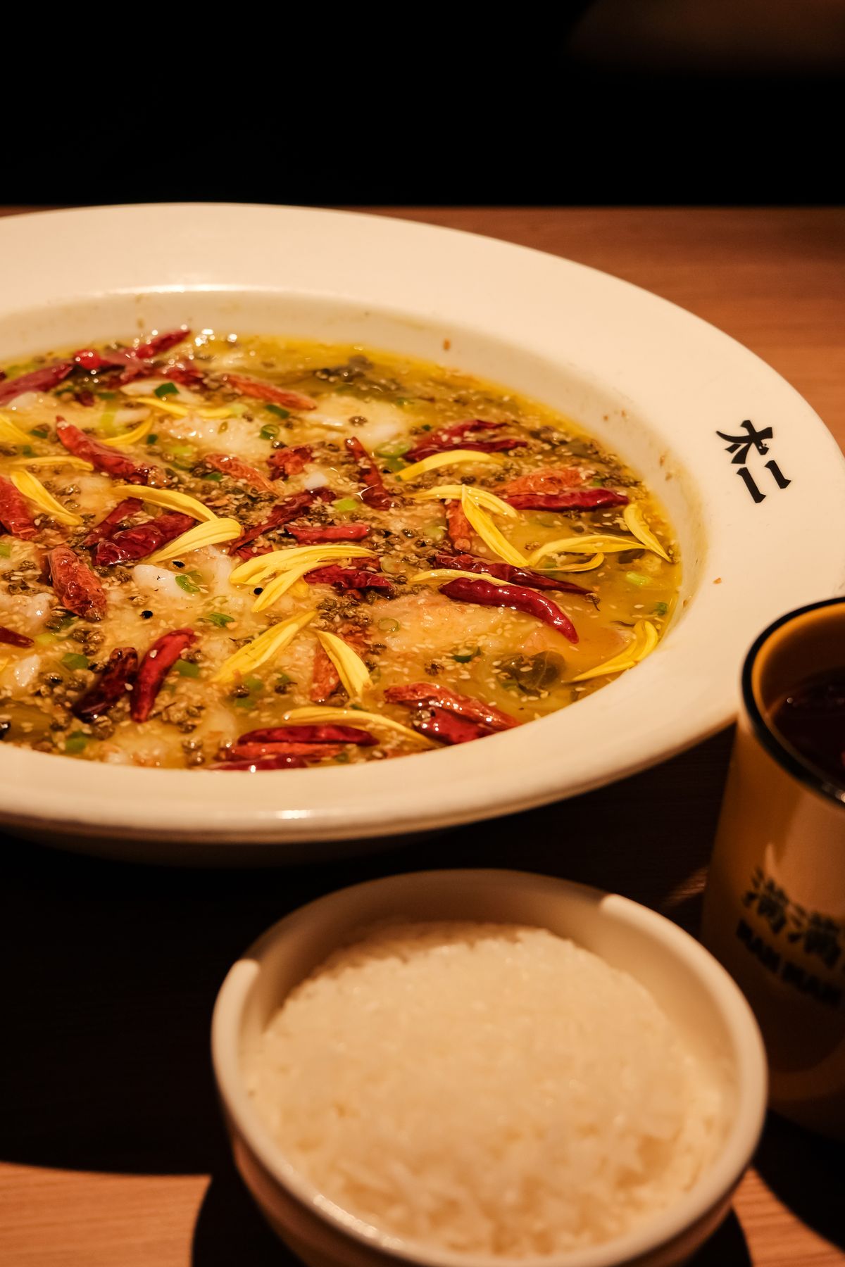 Suan cai yu Sichuan fish soup with fish fillets, pickled greens, dried chilies, peppercorns, and rice.