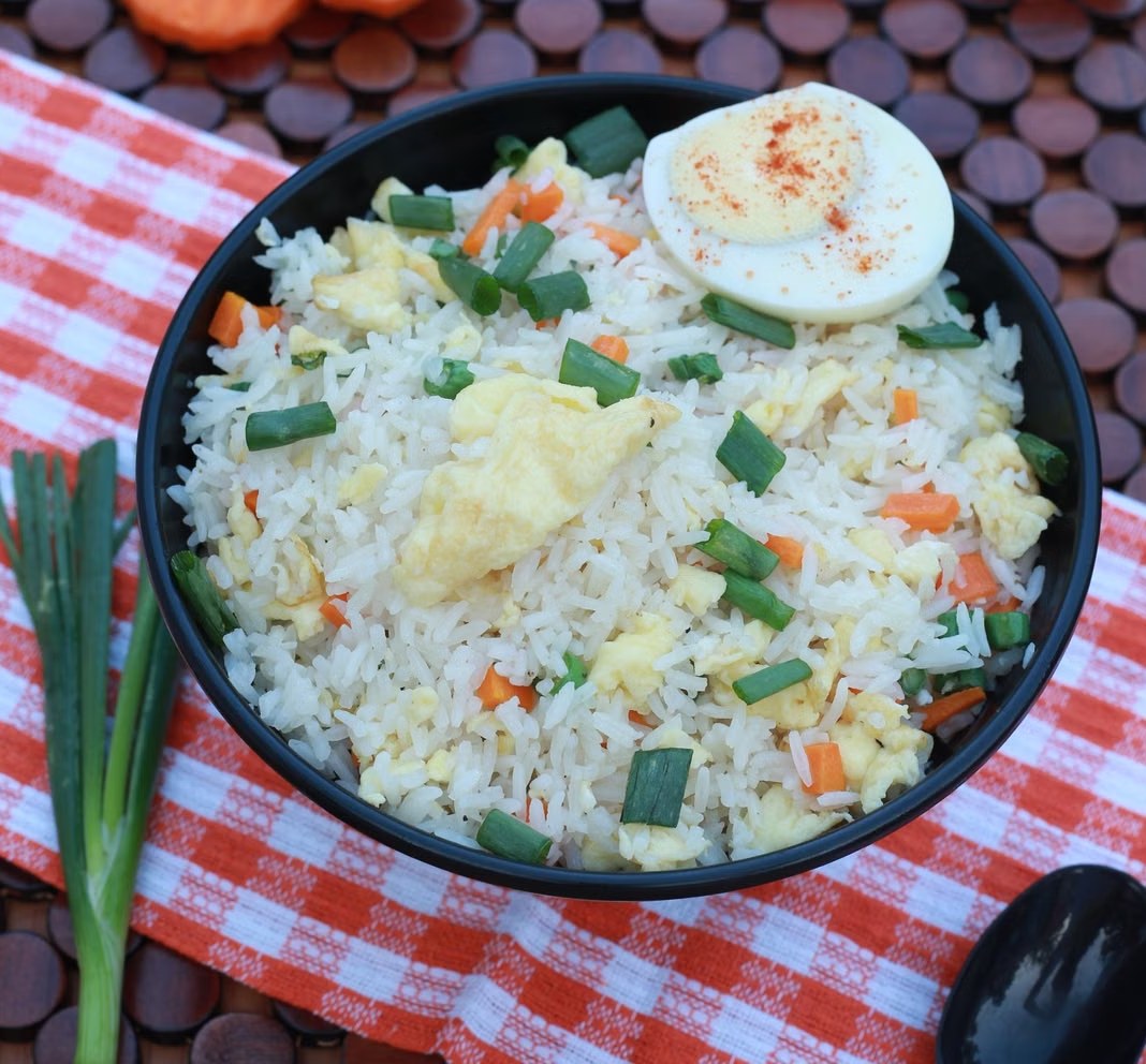 Vegetable egg fried rice with scallions, carrots, and soft egg pieces.